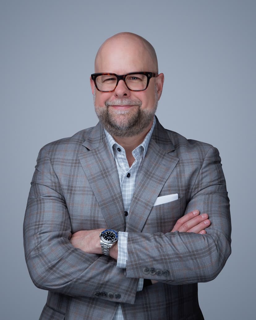 Professional corporate headshot with a neutral, cohesive background